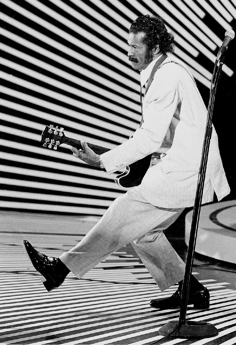 In this April 4, 1980 file photo, guitarist and singer Chuck Berry performs his "duck walk" as he plays his guitar on stage. Chuck Berry died Saturday at the age of 90. 