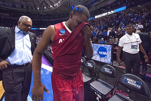 Arkansas senior Manny Watkins and his father, Razorbacks assistant coach Melvin Watkins walk off the floor following a 72-65 loss to North Carolina in the NCAA Tournament on Sunday, March 19, 2017, in Greenville, S.C.