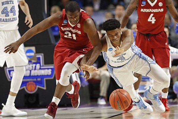 Arkansas' Manuale Watkins (21) and North Carolina's Isaiah Hicks (4) chase a loose ball during the first half in a second-round game of the NCAA men's college basketball tournament in Greenville, S.C., Sunday, March 19, 2017. (AP Photo/Chuck Burton)

