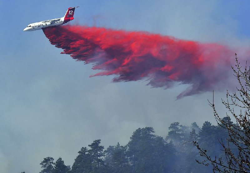 An air tanker plane drops retardant on a wildfi re west of Boulder, Colo., on Sunday.