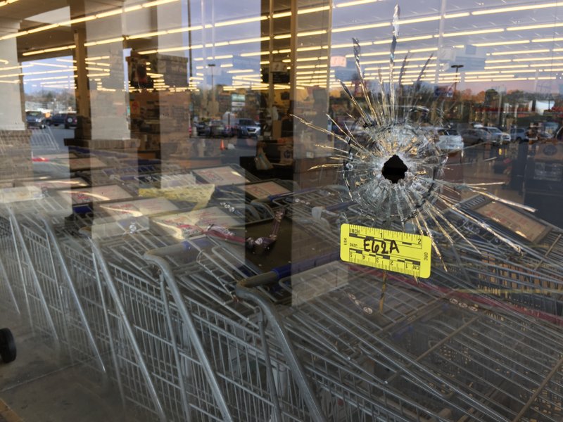 A bullet hole is seen in a window of a Kroger grocery store. Police say one person died after being shot in the parking lot.