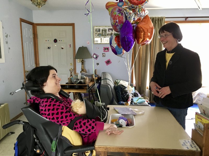 In this March 11, 2017 photo, Stephanie Bushey, right, uses sign language and eye movements to communicate with her daughter, Katie, at their home in West Chazy, N.Y.