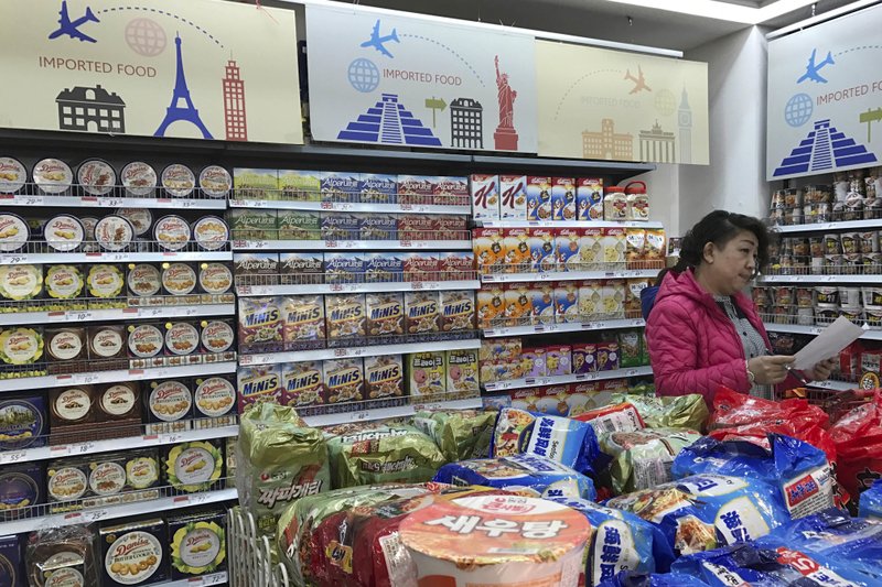 In this photo taken Friday, March 17, 2017, a vendor takes stock of imported food at a mall in Beijing, China.