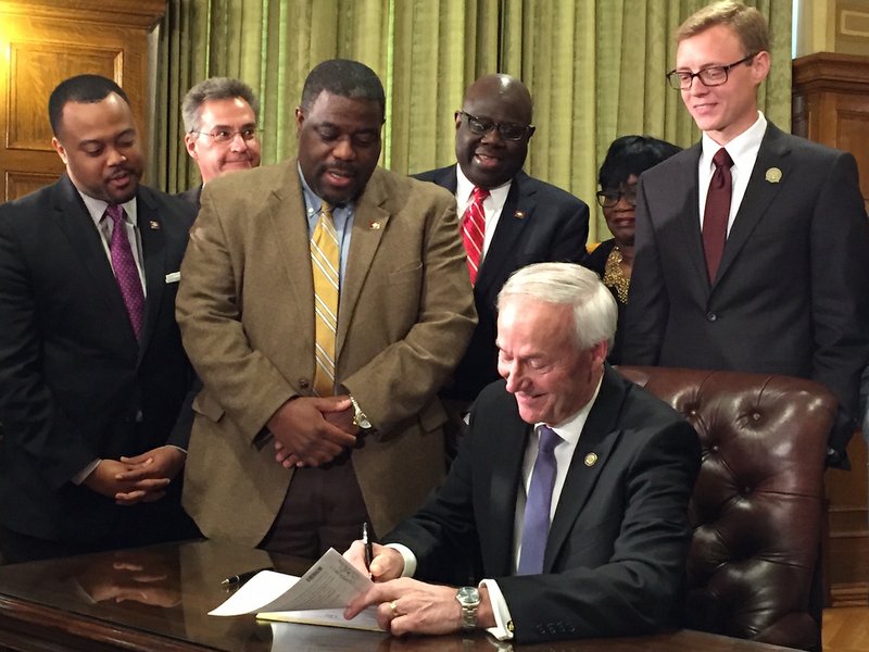 Arkansas Gov. Asa Hutchinson on Tuesday, March 21, 2017, signs into law a bill that ends dual holiday status commemorating civil-rights icon Martin Luther King Jr. and Confederate general Robert E. Lee.
