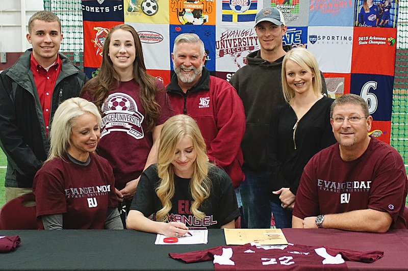 Photo by Randy Moll Amber Ellis, a Gentry senior (center), with her mom and dad, Jennifer and Mike Lundholm, accompanied by brother Alex Ellis, sister Katie Ellis, Evangel Coach Bruce Deaton, and brother and sister-in-law Jordan and Candace Lundholm, signed her letter of intent on March 15 (2017) to attend Evangel University in Springfield, Mo., this fall and to play soccer there.