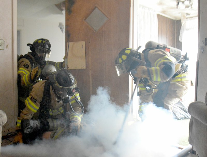 Michael Burchfiel/Herald-Leader Firefighters completed a training exercise that involved searching a house for the source of a fire and rescuing a victim last week.