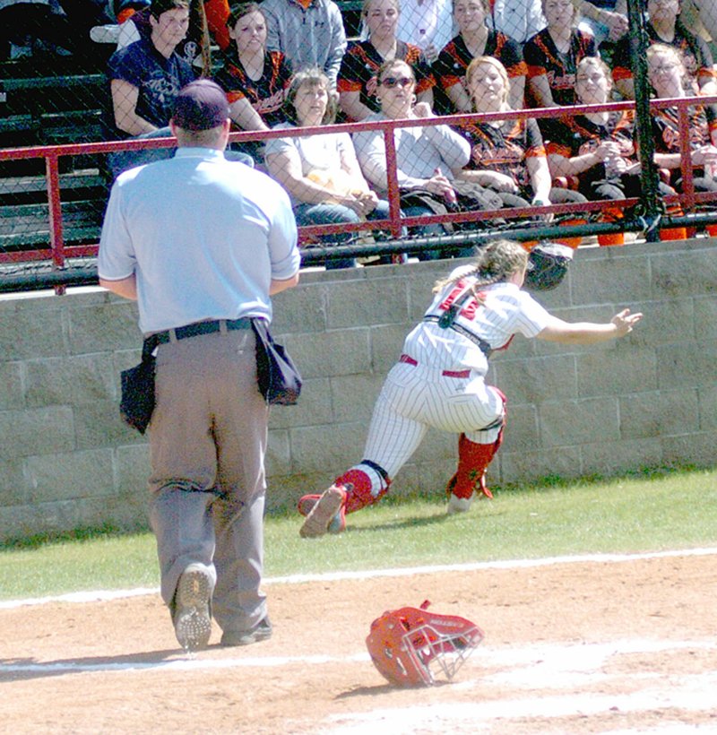 MARK HUMPHREY ENTERPRISE-LEADER Farmington catcher Alyssa Reed makes an athletic play to record an out near the wall. She made a rolling catch and hung on during a 7-2 setback against Cabot on Saturday during the Farmington/Fayetteville Invitational Softball tournament held last weekend.