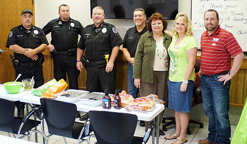 Photo by Randy Moll Grand Savings Bank in Gentry treated police officers to a meal on Friday in appreciation for their work to protect the Gentry community. Police officers Rick Lane, Clay Stewart, Charles Strickland, Chief Keith Smith and office manager Marie Bailey are pictured with bank employees Carmen Arnold and Mike Wilkins at the noon dinner served at the police station.