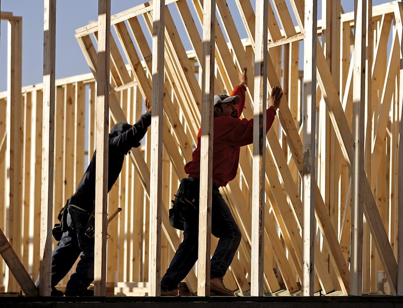 Arkansas Democrat-Gazette/File Photo Workers lift a wall into place while building apartments in Bentonville