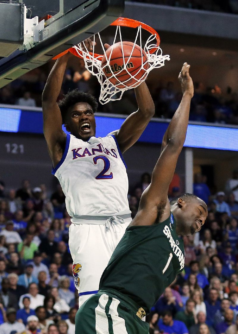 Kansas guard Lagerald Vick (left) dunks over Michigan State defender Joshua Langford during their second-round game last week. The Jayhawks have won their first two tournament games by an average of 29 points but might have a tough time with Purdue because of the Boilermakers’ size advantage. 