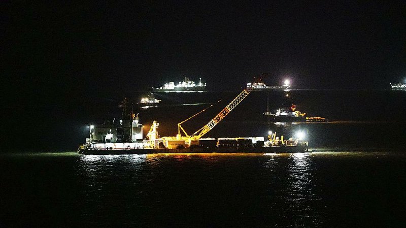 A crane works to lift the Sewol ferry Wednesday from the water off Jindo, South Korea, in this photograph provided by the South Korean Maritime Ministry. 