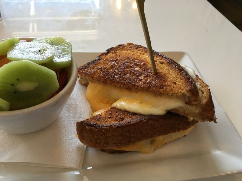 Six cheeses ooze out from between two slices of wheatberry bread in the eponymous Main Cheese sandwich, with a fruit cup on the side.