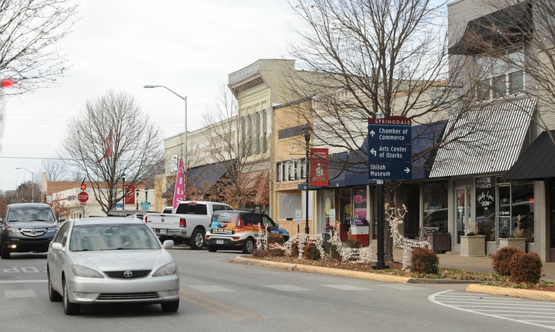 NWA Democrat-Gazette/ANDY SHUPE Traffic moves along Emma Avenue Dec. 22 in downtown Springdale. Downtown Springdale is seeing several new businesses move in and will get a new park this year.