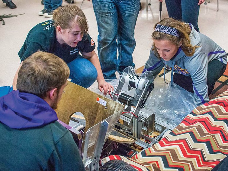 Mayflower High School robotics team members Austin Smith, from left, Briawna Stigall and Reagan Brincks unpack the robot they took to the Arkansas Rock City Regional competition. The team, Metal Eagles 6640, received the Rookie All-Star Award and earned a bid to the world competition, set to begin April 19 in Houston, Texas, but members must raise $12,000 for the trip.
