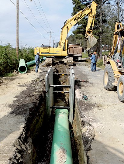 The Sentinel-Record/Richard Rasmussen SEWER SYSTEM IMPROVEMENTS: Coakley Co., Inc. employees install a section of the new 4-mile Stokes Creek force main Thursday in the 200 block of TV Hill. The main will end at the Hot Springs Creek pump station, where it will connect to the Fairwood force main.