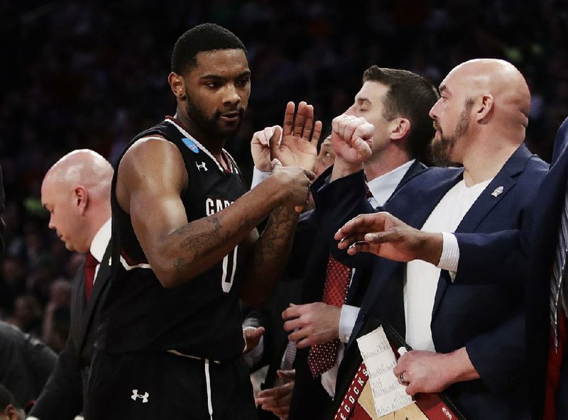South Carolina guard Sindarius Thornwell is greeted by coaches as he comes off the floor late in the second half of a 70-50 victory over Baylor in the East Regional in Madison Square Garden in New York.