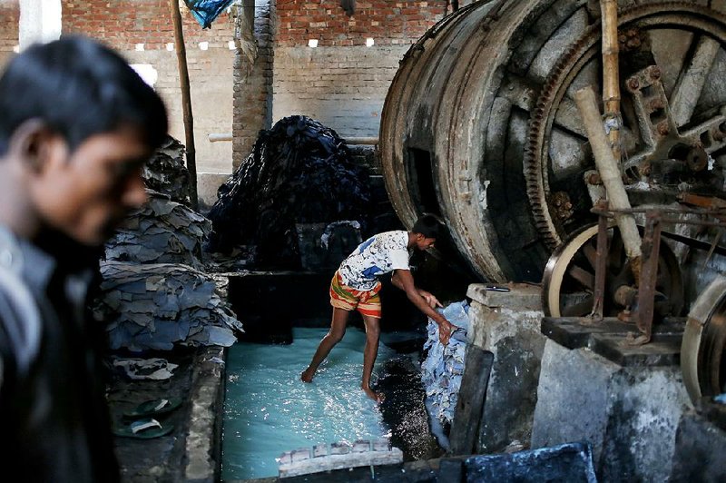 A Bangladeshi boy processes hides inside a factory in the Hazaribagh tannery area in Dhaka.


