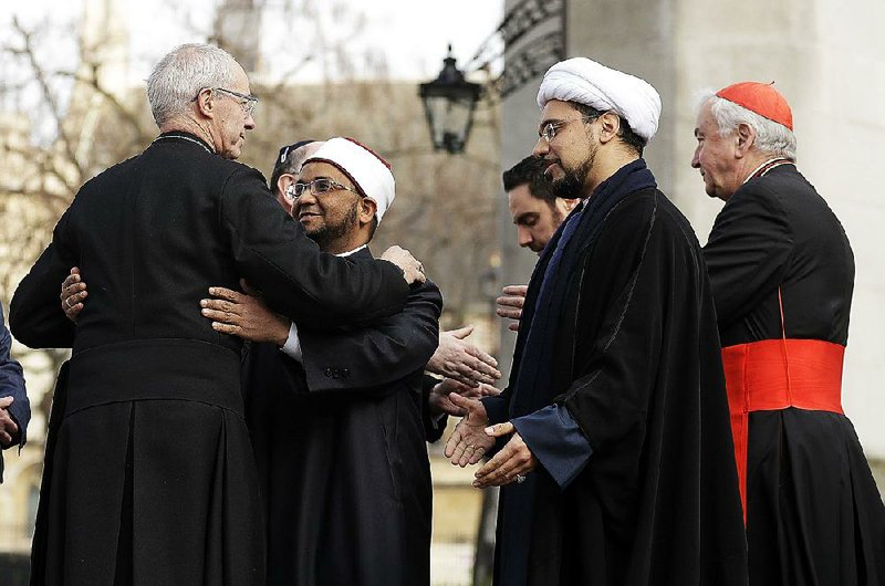 Archbishop Justin Welby (left) greets Sheikh Ezzat Khalifa as Sheikh Mohammad al Hilli and Cardinal Vincent Nichols join other faith leaders for a vigil Friday at Westminster Abbey in London.