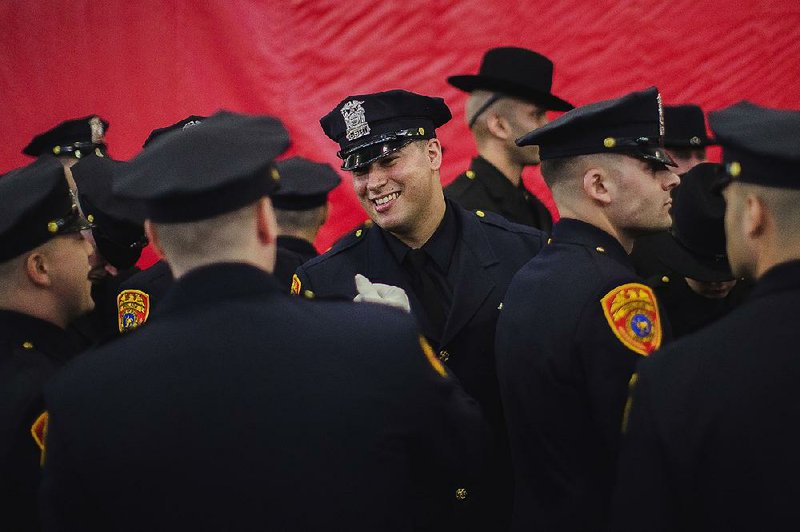 Matias Ferreira, center, celebrates with his colleagues during their graduation from the Suffolk County Police Department Academy at the Health, Sports and Education Center in Suffolk, N.Y., Friday, March 24, 2017.  