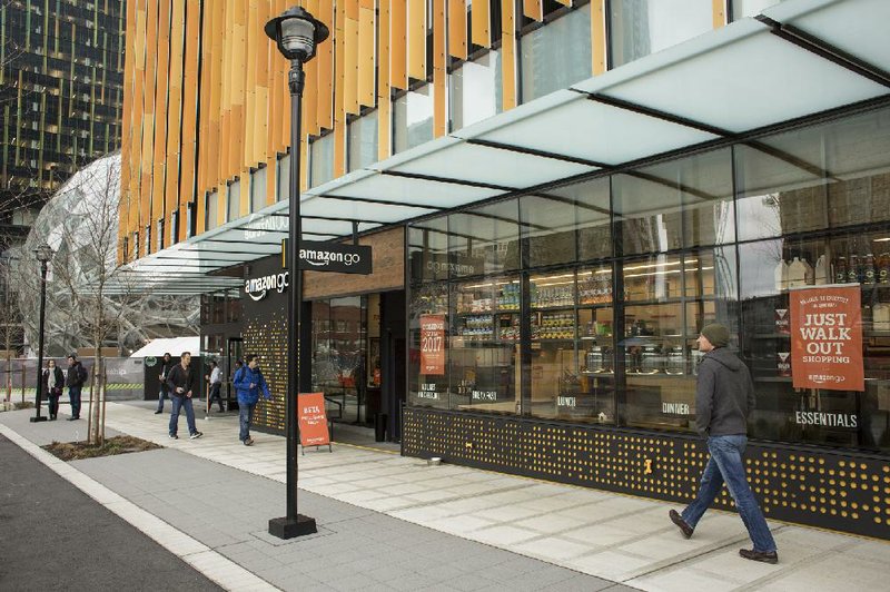 Pedestrians walk past the new Amazon Go grocery store in Seattle in early March.