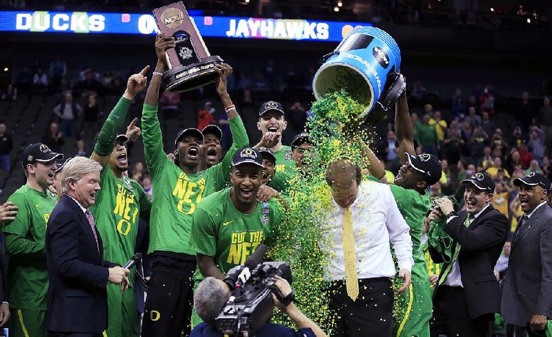 Oregon players celebrate with Coach Dana Altman (right) after Saturday’s victory over Kansas in Kansas City, Mo. Altman, who was the Arkansas Razorbacks’ coach for one day in March 2007 before returning to Creighton, will coach in his first Final Four.