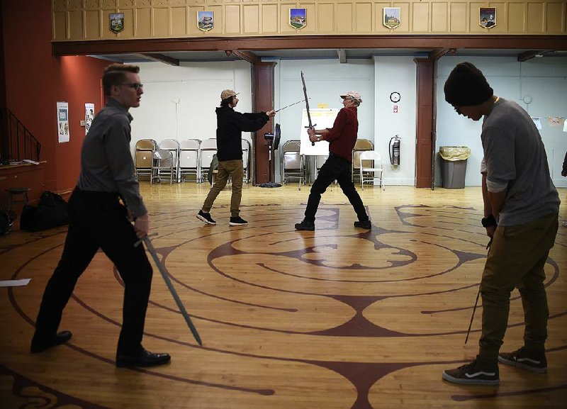 Kevin Coleman (background, right), director of education at Shakespeare & Company, works with a teenager portraying a soldier as another young offender (front left) in the role of Macbeth practices a sword fight with a fellow actor playing Macduff during a rehearsal in Pittsfield, Mass.
