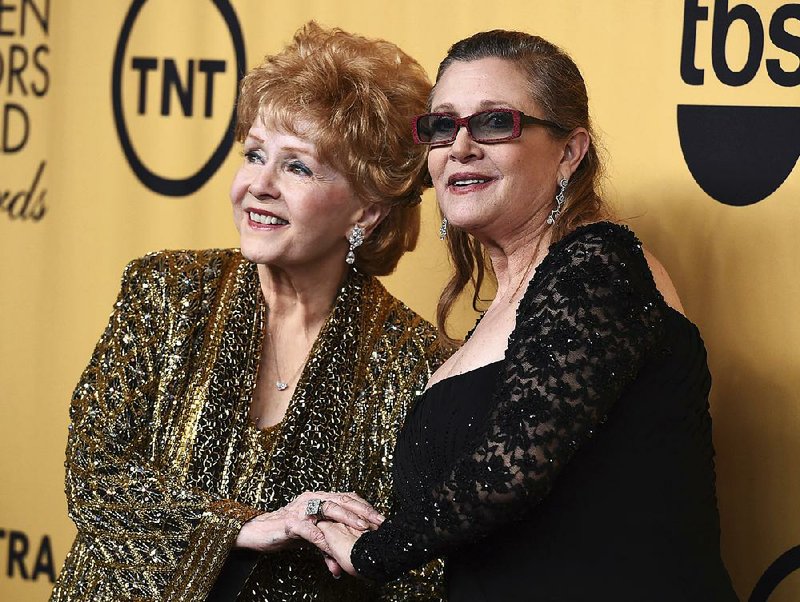 In this Jan. 25, 2015 file photo, Debbie Reynolds, winner of the Screen Actors Guild lifetime award, left, and Carrie Fisher pose in the press room at the 21st annual Screen Actors Guild Awards in Los Angeles.