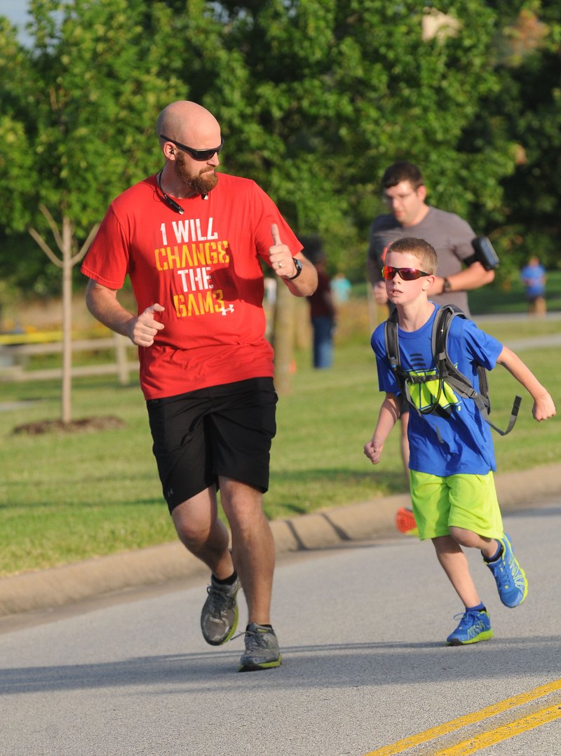 File photo Trey Robinson of Centerton and his son, Peyton, run together during a previous Autism Involves Me 5K. This year, AIM will host a golf event on May 12 and the Family Fun Walk May 13. To register, visit aimnwa.org.