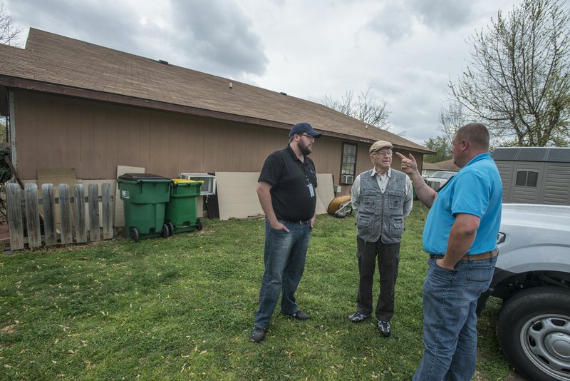 Toby Lankford (right) and Logan West (left), both code enforcement officers, talk Friday with Roger Baker at one of Baker’s properties in Springdale. West is new to the department and Lankford was taking him around to talk to some of the people they will regularly work with. The pair cover the city west of Thompson Street.