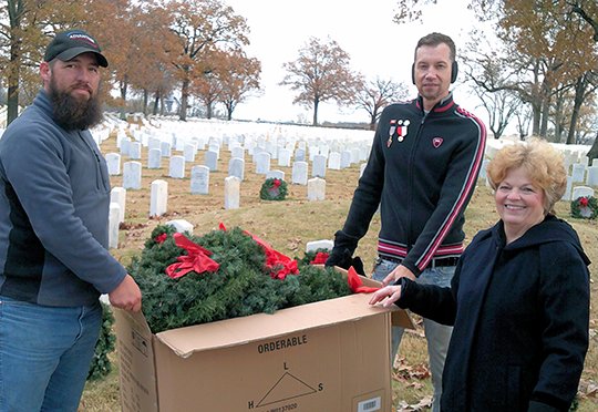Submitted photo VOLUNTEER OF THE QUARTER: Nickie Fitzgerald and Randall Freeman receive direction from Mary Ellen Laursen on where to place wreaths on the nearly 3,000 grave sites of unknown soldiers buried at Little Rock National Cemetery.