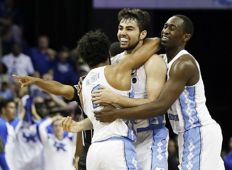 North Carolina forward Luke Maye (center) is grabbed by teammates Joel Berry (left) and Theo Pinson after Maye hit the game-winning basket with 0.3 seconds left to lift the Tar Heels past Kentucky 75-73 on Sunday in the South Regional final at the FedEx Forum in Memphis.