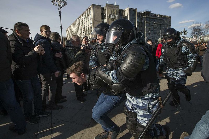 Police detain a protester in a crackdown on unsanctioned demonstrations Sunday in downtown Moscow.