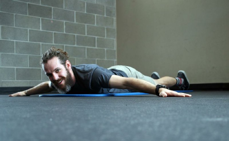 Eric Godwin does step 1 of the Superwide Plank exercise 