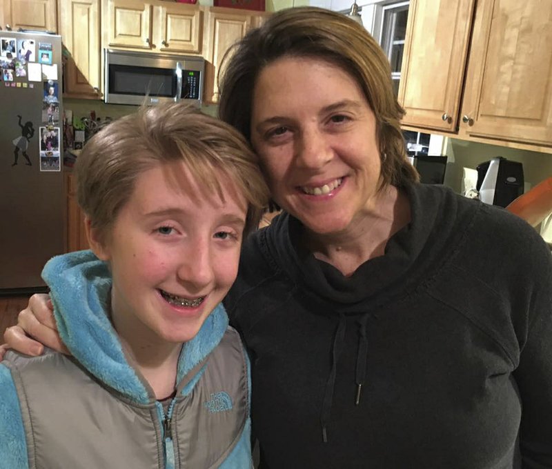 In this photo provided by Clare Schexnyder, small business owner Clare Schexnyder, 49, poses with her daughter, Sofi, in their kitchen in Decatur, Ga., on Jan. 27, 2017.