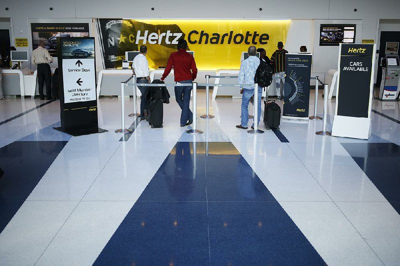 Customers wait in line at a Hertz Global Holdings Inc. rental location inside Charlotte Douglas International Airport in Charlotte, N.C., in February.