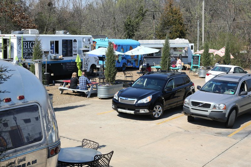 Customers cars are parked March 8 in front of several food trucks and mobile vendors at the Yacht Club on College in Fayetteville.