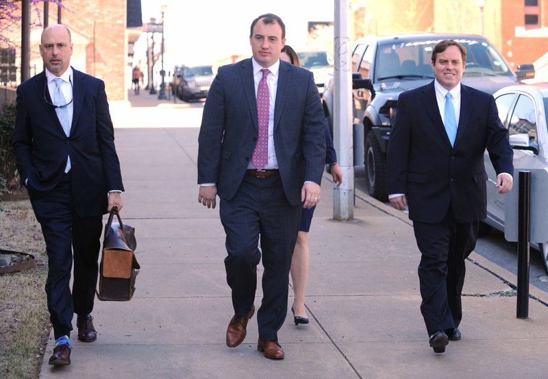 Former state Sen. Jon Woods (right) walks Tuesday with his attorney, Patrick Benca (far left), and others from the Benca Law Firm to the John Paul Hammerschmidt Federal Building in Fayetteville.