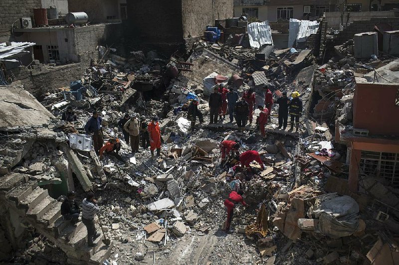 Rescue teams work on the debris of a destroyed house to recover the bodies of people killed during fighting between Iraqi security forces and Islamic State militants on the western side of Mosul, Iraq, on Friday. 