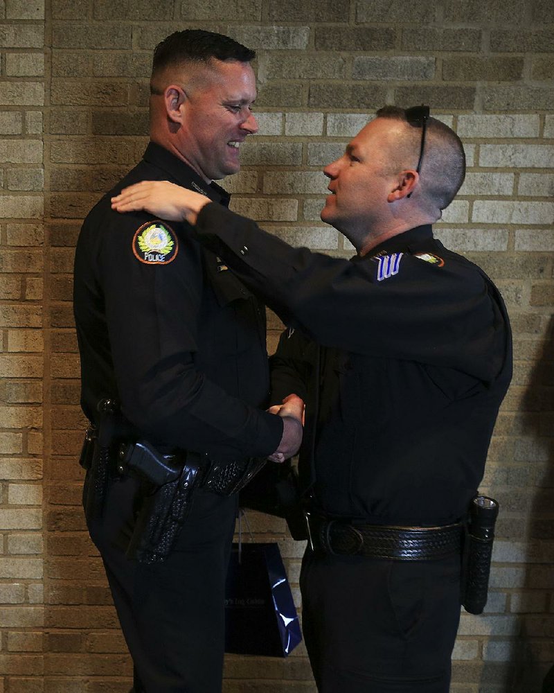 Little Rock Police Sgt. Chris Phillips (right) congratulates officer David Wilson on Tuesday after Wilson and officer Brittany Godfrey received the Chief Stuart Thomas Officer of the Year Award at the Rotary Club of Little Rock’s Police and Fire Department Awards. 
