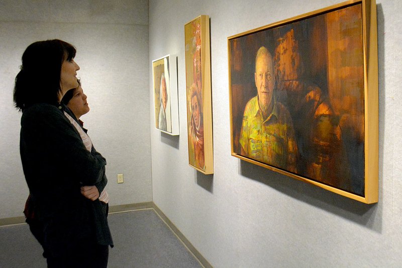 Janelle Jessen/Herald-Leader Students Grace Nast and Kenzie Meeker looked at several paintings by Bruce Herman. The paintings are on display at John Brown University&#8217;s Windgate Visual Arts Center West. The exhibit will be open from March 30 through May 2.