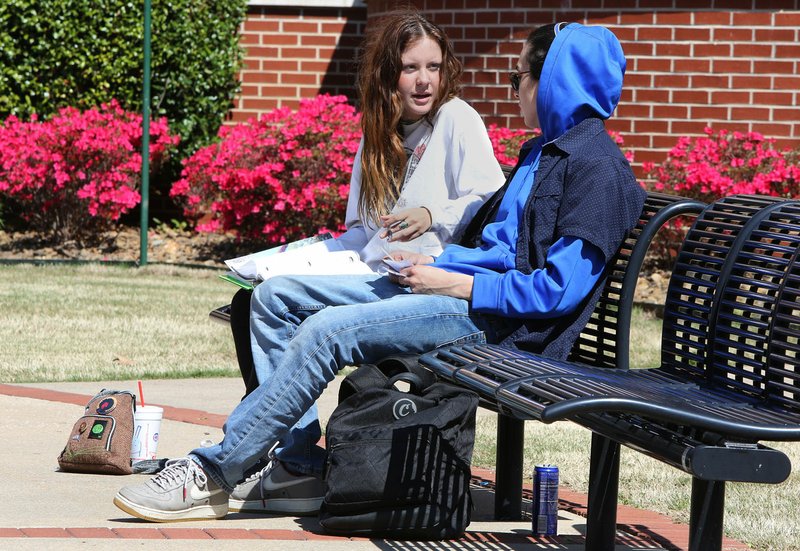 NWA Democrat-Gazette/DAVID GOTTSCHALK Courtney Gracie, a freshman at Northwest Arkansas Community College, studies Tuesday with Oswaldo Arroyo, a sophomore, in the courtyard in front of the Becky Paneitz Student Centerin Bentonville. The college hosted a gun forum Tuesday night.