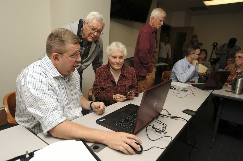 NWA Democrat-Gazette/ANDY SHUPE Ray and June Baggett of Fayetteville speak Tuesday with Lee Beshoner (left), an engineer with FTN Associates in Fayetteville, as they look at an updated floodplain map at the city administration building.