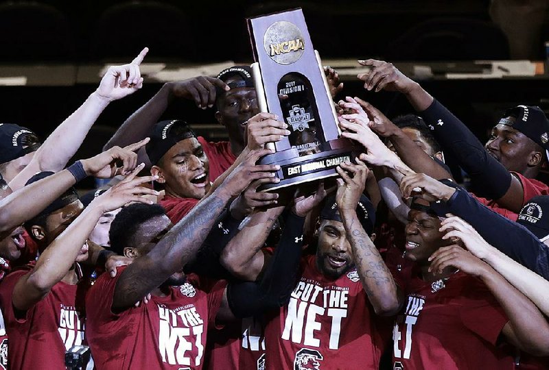 Members of the South Carolina men’s basketball team hold up the East Regional championship trophy after the Gamecocks advanced to their first Final Four by beating Florida last weekend. The Palmetto State has enjoyed a great deal of success over the past year, from Coastal Carolina winning the College World Series in June to Clemson winning the college football title in January.