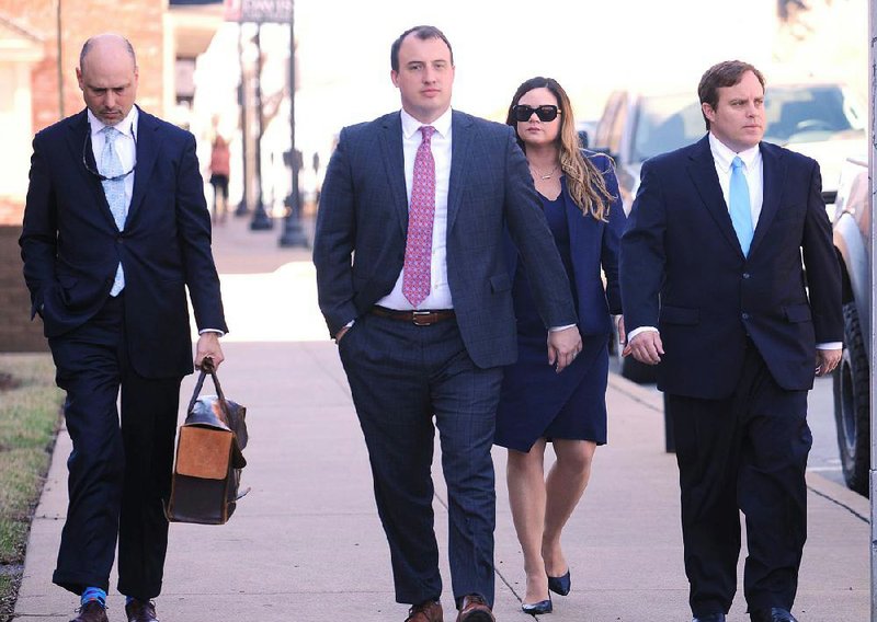 Former state Sen. Jon Woods (right) walks to federal court Tuesday in Fayetteville with his attorney, Patrick Benca (far left), and others from the Benca Law Firm of Little Rock. 