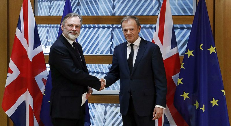 Britain’s European Union representative Tim Barrow (left) delivers the United Kingdom’s notice of its intent to exit the bloc to EU Council President Donald Tusk on Wednesday in Brussels. 