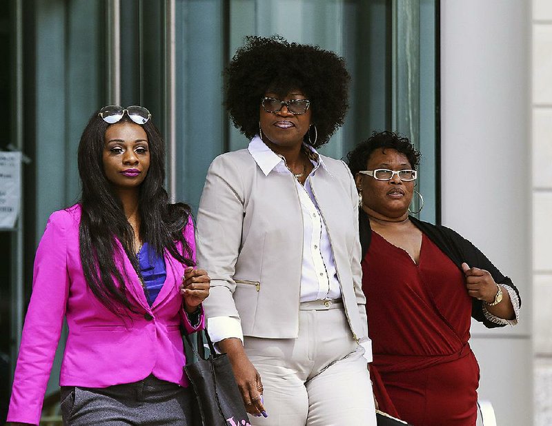 FILE PHOTO: Jacqueline Mills is flanked by relatives in April as she leaves the federal courthouse in Little Rock, where she is on trial, accused of defrauding U.S.-funded food programs for underprivileged children. 