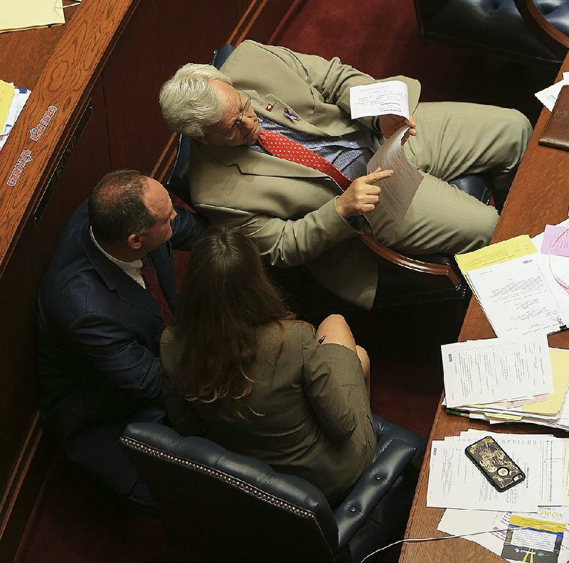 Sen. Eddie Joe Williams (top) confers with Sen. Jimmy Hickey and Sen. Missy Irvin in the Senate chamber Wednesday afternoon. 