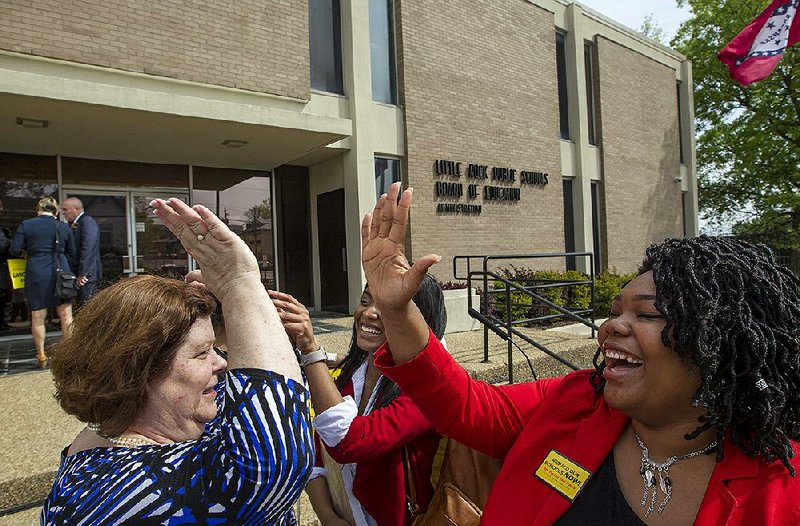 Cathy Koehler (from left), president of the Little Rock Education Association, celebrates Wednesday with Faith Madkins, a senior at McClellan High School, and Kiana Frierson, a senior at J.A. Fair High School, after the Little Rock School District’s debt-service tax election announcement.
