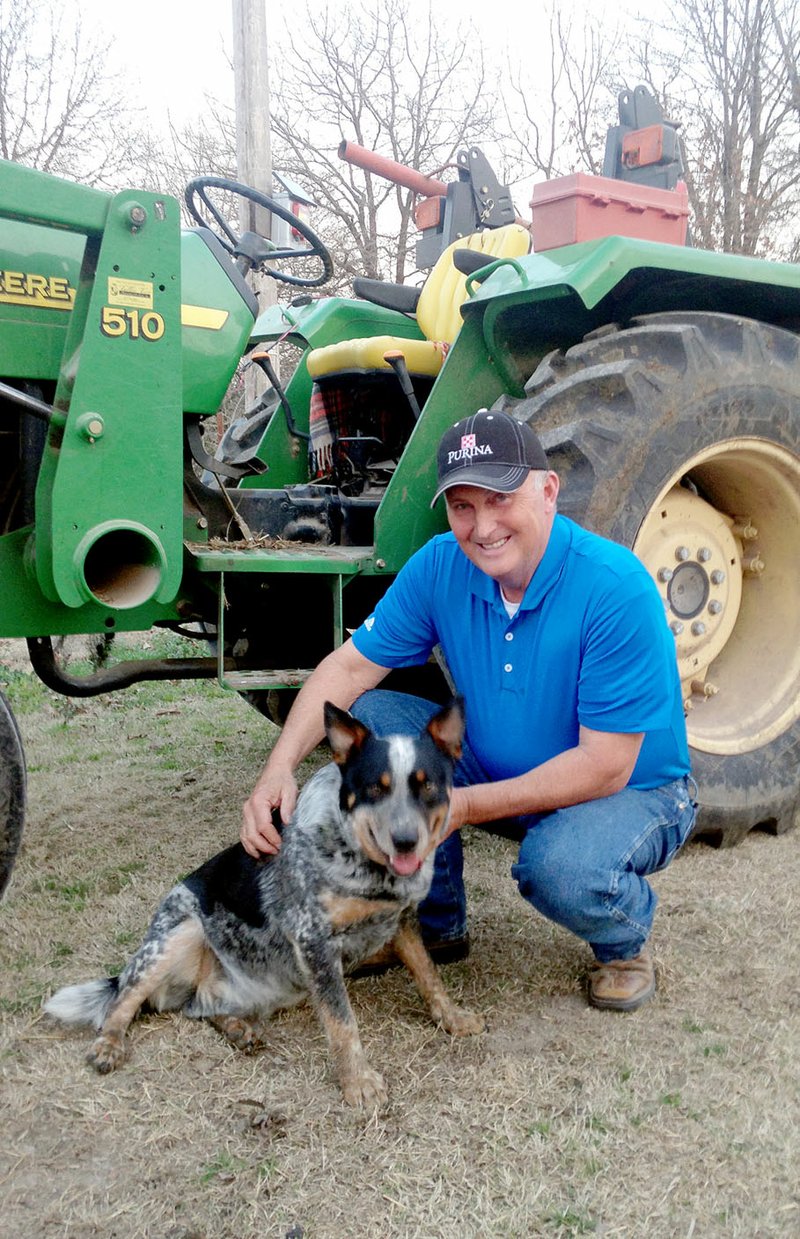 Staff photograph by Sally Carroll Agricultural teacher Perry Mason plays with his dog on his farm near Longview. The FFA leader and Ag teacher has led students at Pea Ridge High School for 27 years.