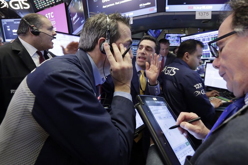 Specialist Peter Mazza, center, works with traders on the floor of the New York Stock Exchange, Wednesday, March 29, 2017. Stocks are opening mostly lower on Wall Street led by declines in utilities and real estate companies. (AP Photo/Richard Drew)